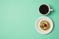 Overhead photo of cup of coffee and plate with fruit cake isolated on the teal backdrop with copyspace Royalty Free Stock Photo