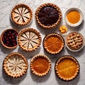 Overhead photo of different pies, tarts, and deserts on white marble table