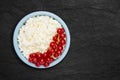 An overhead photo of fresh natural cottage cheese with red currant in a blue ceramic bowl on the black stone plate. Organic eco Royalty Free Stock Photo