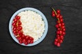 An overhead photo of fresh natural cottage cheese with red currant in a blue ceramic bowl on the black stone plate. Organic eco Royalty Free Stock Photo