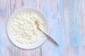 An overhead photo of fresh natural cottage cheese with Vintage old silver spoon in white ceramic bowl on the wooden table. Organic Royalty Free Stock Photo