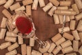 Glass of red wine with corks and corkscrew on a dark rustic background with a place for text, toned image Royalty Free Stock Photo