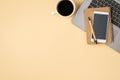 Overhead photo of grey laptop cup of coffee notepad with pen and phone isolated on the beige backdrop with blank space Royalty Free Stock Photo