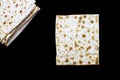 A photo of two pieces of matzah or matza isolated on black background. Matzah for the Jewish Passover holidays. Place for text, co