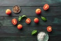 An overhead photo of organic heirloom tomatoes and fresh basil leaves on a dark rustic background with salt and pepper Royalty Free Stock Photo