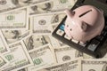 Overhead photo of piggybank pink pig with calculator isolated on the background of dollars Royalty Free Stock Photo