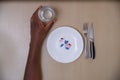 Overhead photo of a plate with pills and forks and a glass of water. Concept of overuse of drugs and medicines