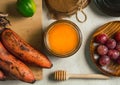 Overhead photograph of still life of organic food, honey, red bananas, grapes, lemon and flowers. 2