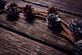 Pine cone and cinnamon sticks on wooden plank Royalty Free Stock Photo