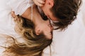 Overhead portrait of two young people in love having fun together lying in cozy bed in morning. Long-haired brunette Royalty Free Stock Photo