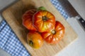 Overhead selective shot of tomatoes stacked on each other on a wooden chopping board