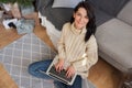 Overhead shot of beautiful young woman shopping online on laptop in cozy Christmas interior. Female sitting on the floor next the Royalty Free Stock Photo