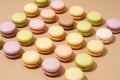 overhead shot of a beige table surface featuring an array of colorful macarons in neat rows