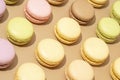 overhead shot of a beige table surface featuring an array of colorful macarons in neat rows