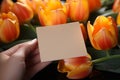 Overhead shot Blank paper card amidst orange and yellow tulips