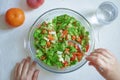 Overhead shot of a bowl with salad and woman`s hands eating. Fruit, vegan diet concept Royalty Free Stock Photo