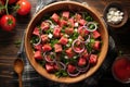 overhead shot of a bowl of watermelon salad on a rustic wooden table