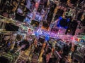 Overhead shot of buildings and streets around Times Square. Advertisements and displays glowing colourful light