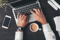 Overhead shot of business person hands typing laptop computer keyboard with cup of coffee on the desk