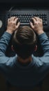 Overhead view of a person typing on a computer keyboard in a dimly lit room, focusing on technology and work Royalty Free Stock Photo