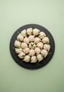 Delicious White Chocolate Truffles Arranged on a Black Slate Plate Against a Green Background Royalty Free Stock Photo