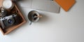 Overhead shot of comfortable workspace with laptop computer, camera, coffee cup and office supplies on white desk Royalty Free Stock Photo