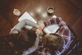 Overhead shot of a couple holding hands over the table near their coffee mugs Royalty Free Stock Photo