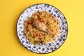 Overhead shot of curry rice and a chicken leg in a decorative plate on a  yellow background Royalty Free Stock Photo