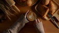 Female hands holding a cup of hot latte coffee with freshly bakery on wooden table Royalty Free Stock Photo