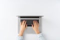 Overhead shot of female hands working on laptop on white desk. Royalty Free Stock Photo