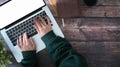 Overhead shot of woman working with laptop computer on wooden table. Royalty Free Stock Photo