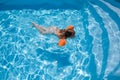 Child with armbands swimming in pool towards stairs Royalty Free Stock Photo