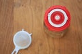 An overhead shot of a glass jar containing water kefir and sealed with a bright red fermentation lid indicating the current date