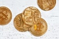 Overhead shot, golden commemorative btc - bitcoin cryptocurrency - coins scattered on white stone board, closeup detail