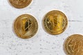 Overhead shot, golden commemorative EOS - EOSIO cryptocurrency - coins on white stone board