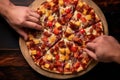 overhead shot of hands placing pineapple chunks on pizza dough