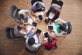 Overhead Shot Of High School Pupils Using Digital Tablets In Group Study Around Tables