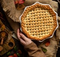 Warm baked apple lattice pie crust in woman hands on sackcloth Royalty Free Stock Photo