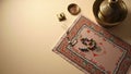 Overhead shot of islamic prayer mat with prayer beads and brass objects on a beige surface space Royalty Free Stock Photo