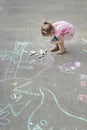 Overhead shot of little Caucasian girl chalking on hopscotch yard Royalty Free Stock Photo