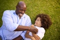 Overhead Shot Of Loving Grandfather And Grandson Lying On Grass Laughing Together