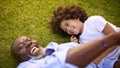 Overhead Shot Of Loving Grandfather And Grandson Lying On Grass Laughing Together