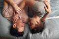 Overhead Shot Of Loving Same Sex Male Couple Lying On Bed At Home Hugging Together