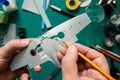 Overhead View Of Man Building Scale Model Aeroplane From Kit On Cutting BoardWith Tools And Materials