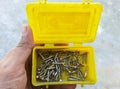 Overhead shot of a man holding a small yellow toolbox with flathead screws Royalty Free Stock Photo
