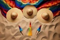 overhead shot of maracas, sombrero and mexican poncho on a sandy beach