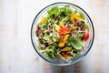 overhead shot of a mixed taco salad in a glass dish