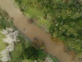 Overhead shot of a muddy river and surrounding vegetation