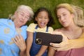 Overhead Shot Of Multi-Generation Female Family Lying On Grass Taking Selfie On Mobile Phone Royalty Free Stock Photo