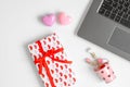 Overhead shot of Notebook laptop, gifts box with red ribbon, pink heart on white background. Flat lay top view office working
